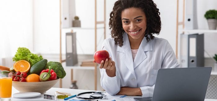 A nutritionist holds an apple